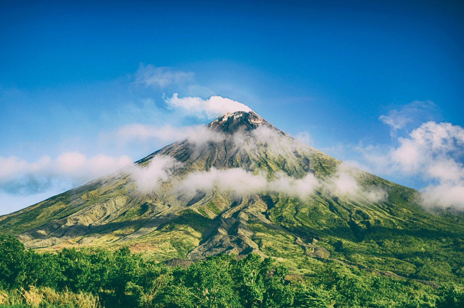 Stunning view of Mayon Volcano surrounded by blue skies and clouds in Bicol, Philippines.